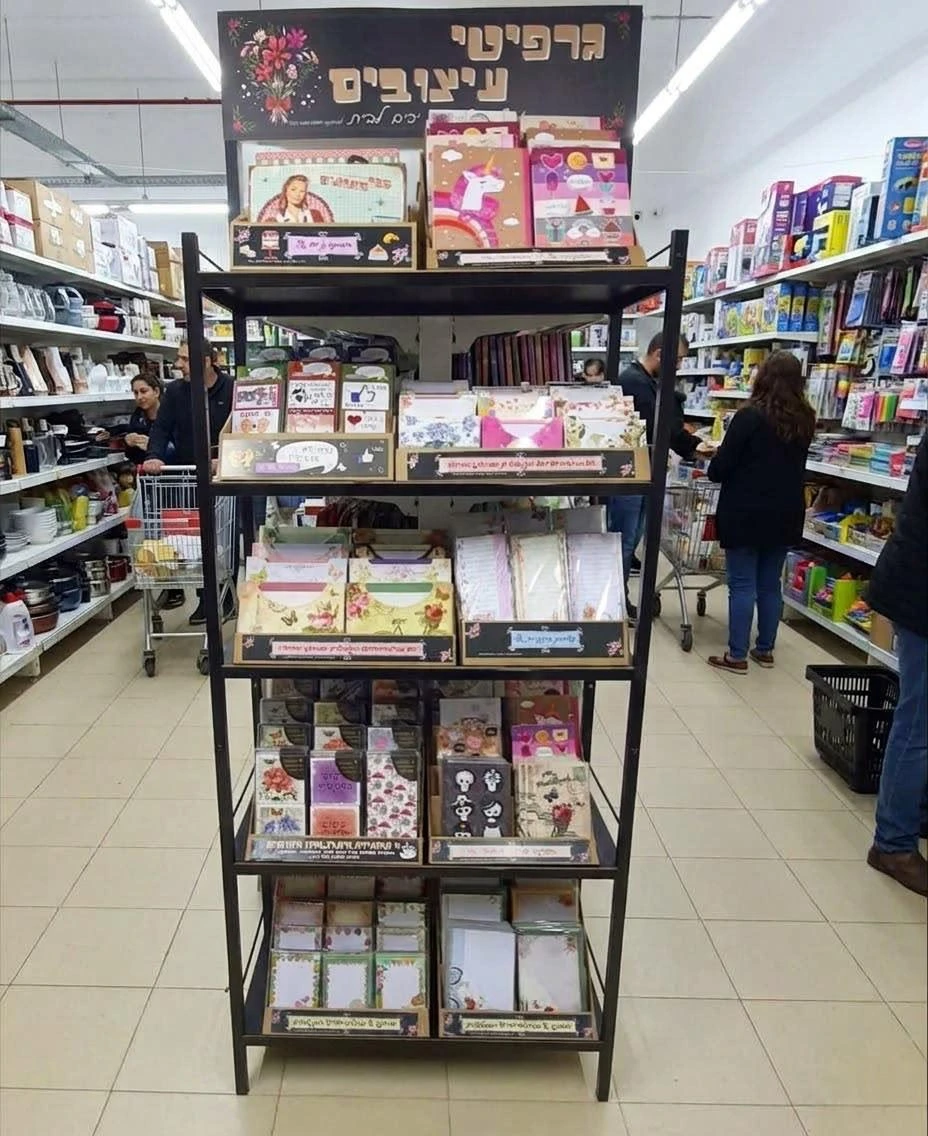 מתקן תצוגה של גרפיטי עיצובים בחנות, עם כרטיסי ברכה ומוצרי נייר